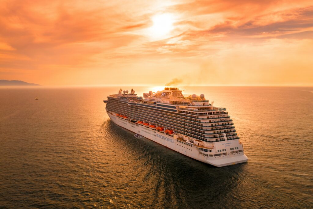 best cruises for families showing family of four on cruise ship deck with waterslide and ocean view in background