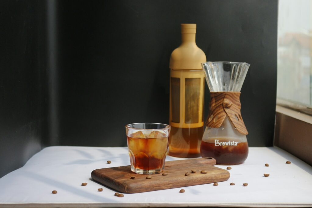 best coffee for cold brew showing dark roast whole coffee beans next to a mason jar of col
