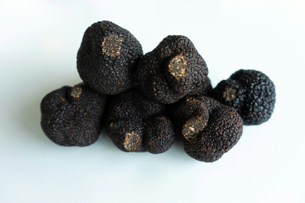 what is a truffle showing fresh black and white truffles on a wooden board with a truffle shaver representing the two main types of culinary truffles used in fine dining
