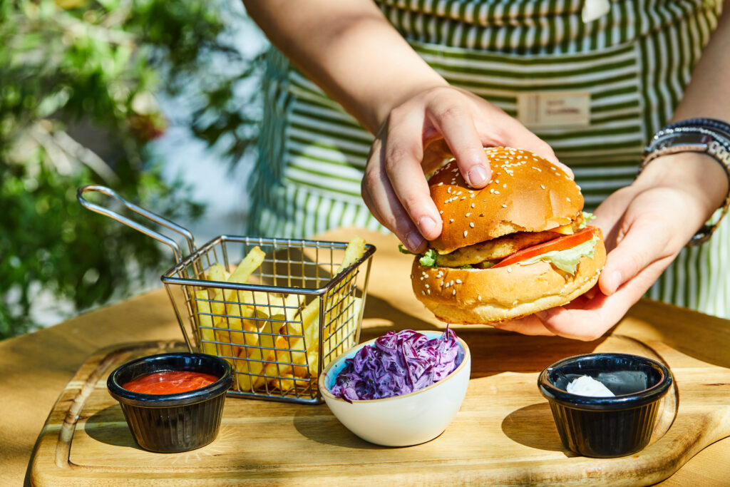 best burgers in san diego showing a juicy double cheeseburger with caramelized onions and crispy fries on a wooden tray at a San Diego burger restaurant