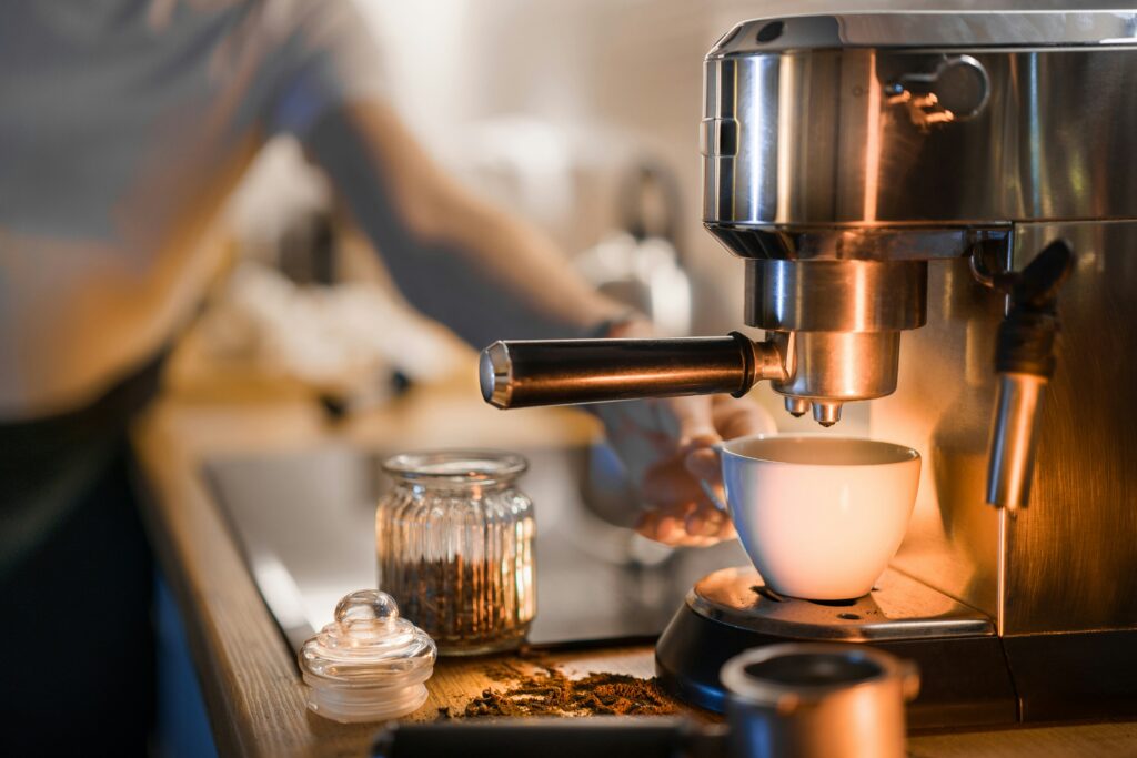 best super automatic espresso machine showing De'Longhi Magnifica Plus and Jura E8 on a kitchen counter with a freshly poured espresso and automatic milk frother in use