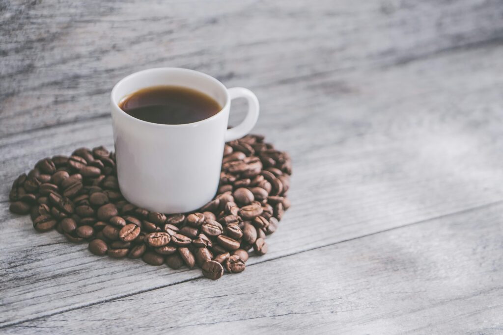 gifts for coffee lovers showing Timemore C2 hand grinder, gooseneck kettle, specialty coffee bag, and AeroPress on a wooden surface as top coffee gift ideas