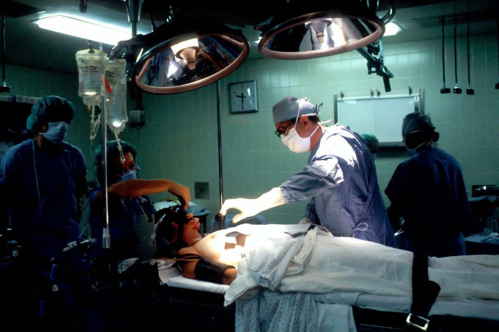 post op care showing a patient recovering in a hospital bed with a nurse checking vital signs representing post-operative care and surgery recovery guidelines
