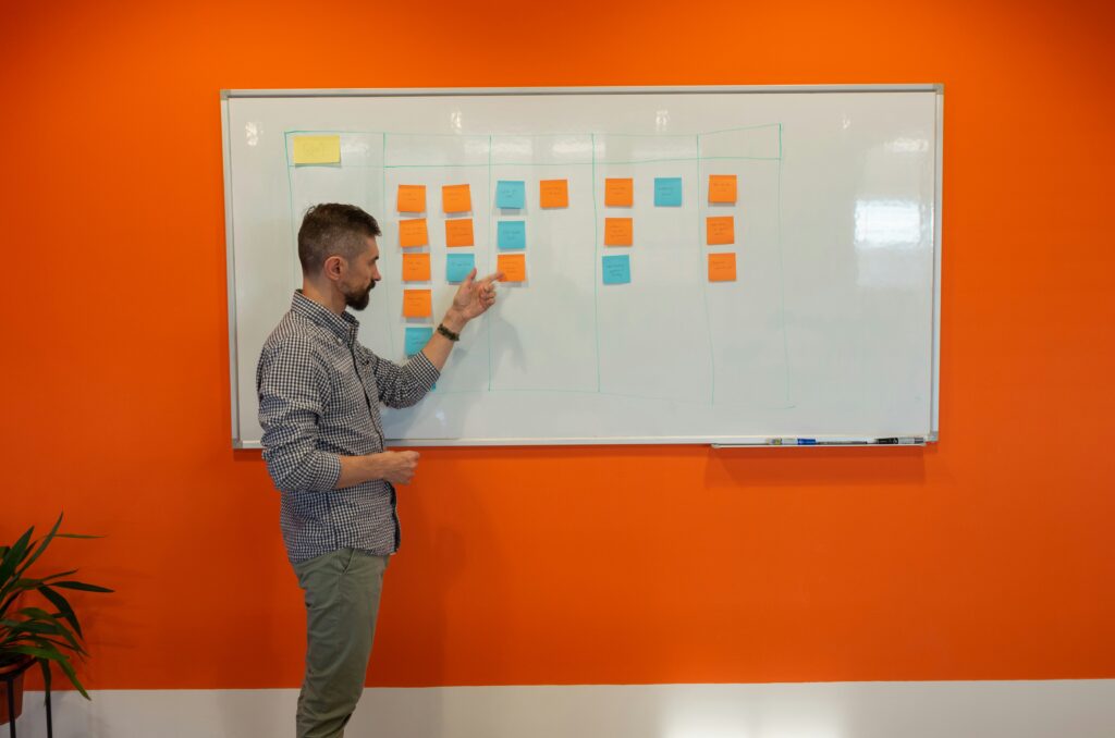how to clean a whiteboard showing a person wiping a dry erase board with a microfiber cloth and spray bottle representing the best methods for cleaning whiteboards and removing dry erase marker ghosting